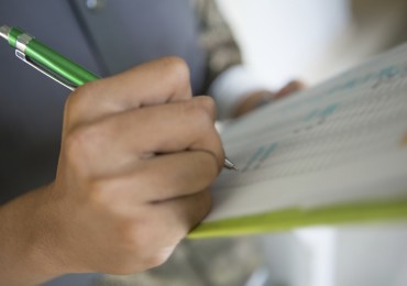 Man with pen writing on clipboard - Inspection Templates.