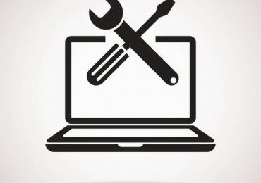 Screwdriver and wrench crossed in front of a laptop - laptop-tools-blog.